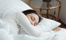Person sleeping in white bed