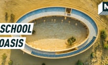 Aerial shot of the oval school amid the desert, solar panels seen on the roof. Caption reads: school oasis