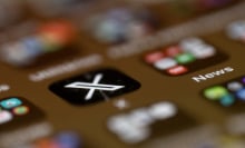 A blurry phone screen, with only the X app logo in focus.