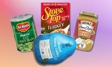 a frozen turkey, box of stuffing, can of green beans, and container of gravy from Target against a pink and purple background