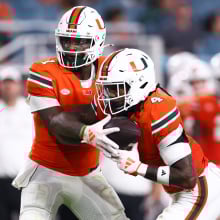 Cam Ward #1 of the Miami Hurricanes hands off the ball to teammate Mark Fletcher Jr. #4 during the first half of the game against the Virginia Tech Hokies at Hard Rock Stadium on Sept. 27, 2024, in Miami Gardens, Florida.
