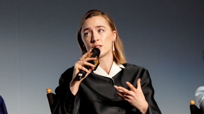 Saoirse ronan on stage, speaking into a microphone