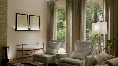living room with two armchairs lit by soft white lamps