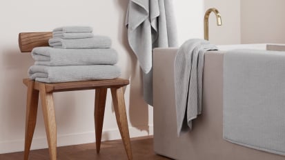 Light grey towels in an earthy bathroom