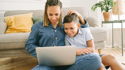 woman and boy watching TV on laptop