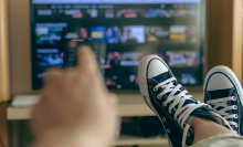 person holding remote up to tv