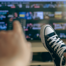 person holding remote up to tv