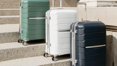 Black, white, and green suitcases lined up on stairs